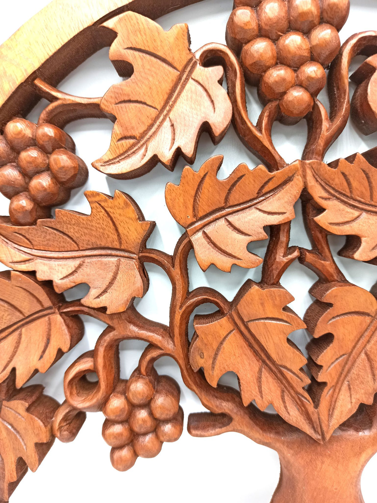 Tableau mural rond en bois de suar chantourné représentant un Arbre de Vie aux branches ornées de feuilles et de grappes de raisin, diamètre 40 cm. Ozora.
