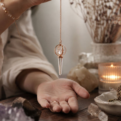 Pendule Merkaba en cristal de roche et cuivre avec étoile tournante. Un pendule divinatoire élégant pour la radiesthésie, la méditation et les pratiques énergétiques.