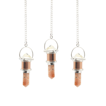 Pendule original au design raffiné, qui associe la chaleur du cuivre à la transparence lumineuse du cristal de roche et aux nuances chaleureuses de la pierre de soleil. Ozora