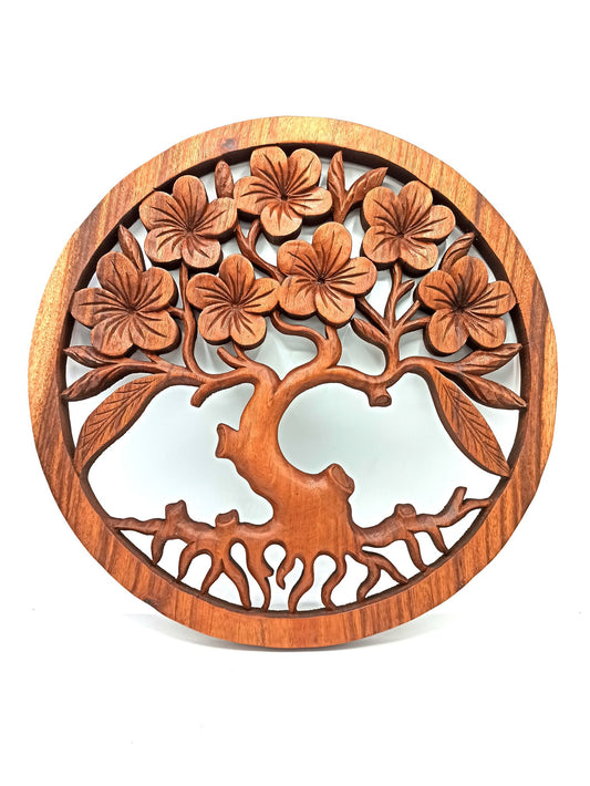 Tableau mural rond en bois de suar chantourné représentant un Arbre de Vie aux branches ornées de fleurs de frangipanier sculptées, diamètre 40 cm. Ozora.
