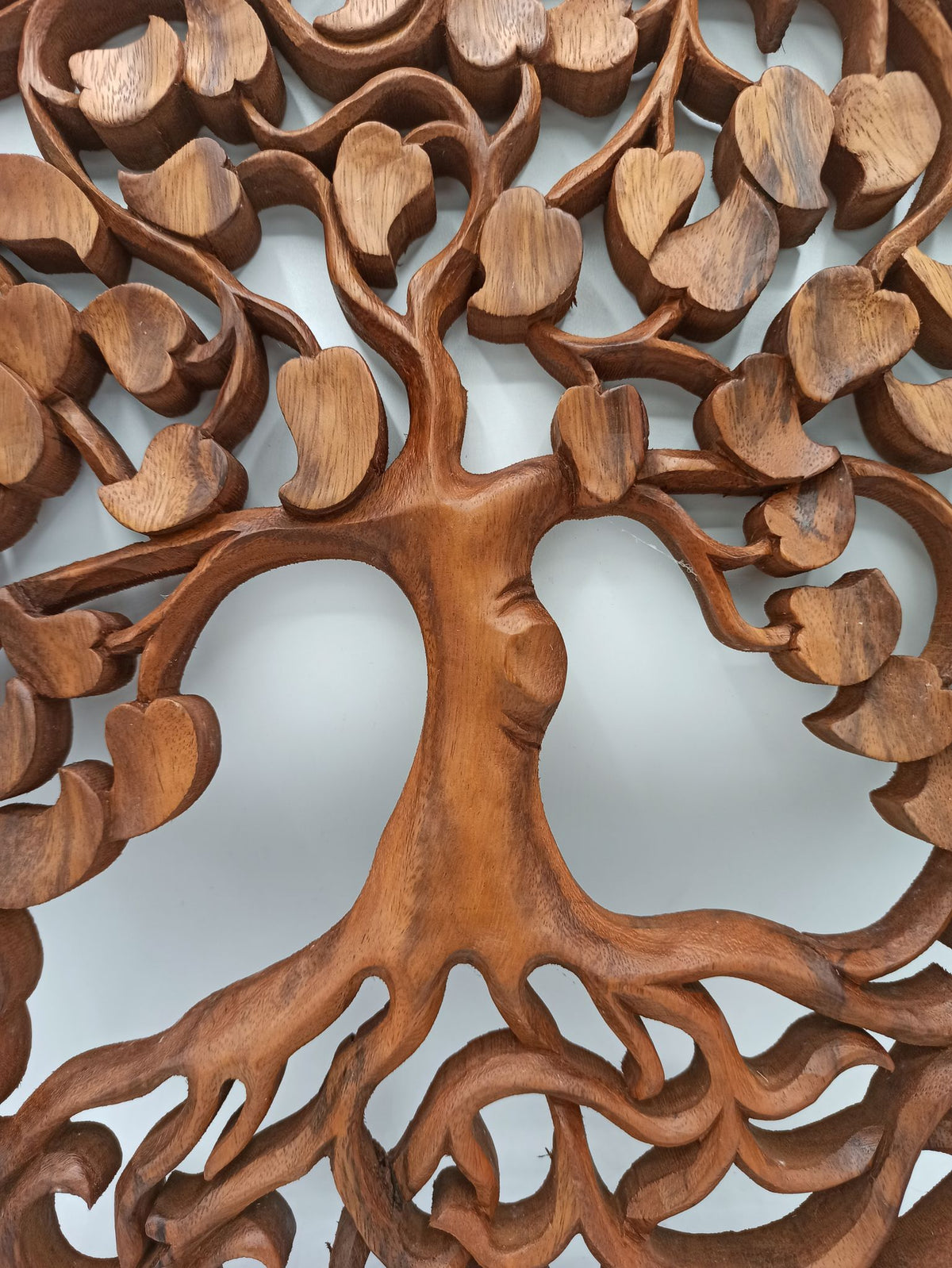 Tableau mural rond en bois de suar chantourné représentant un Arbre de Vie aux branches ornées de feuilles en forme de cœur, diamètre 40 cm. Ozora.