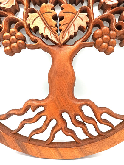 Tableau mural rond en bois de suar chantourné représentant un Arbre de Vie aux branches ornées de feuilles et de grappes de raisin, diamètre 40 cm. Ozora.