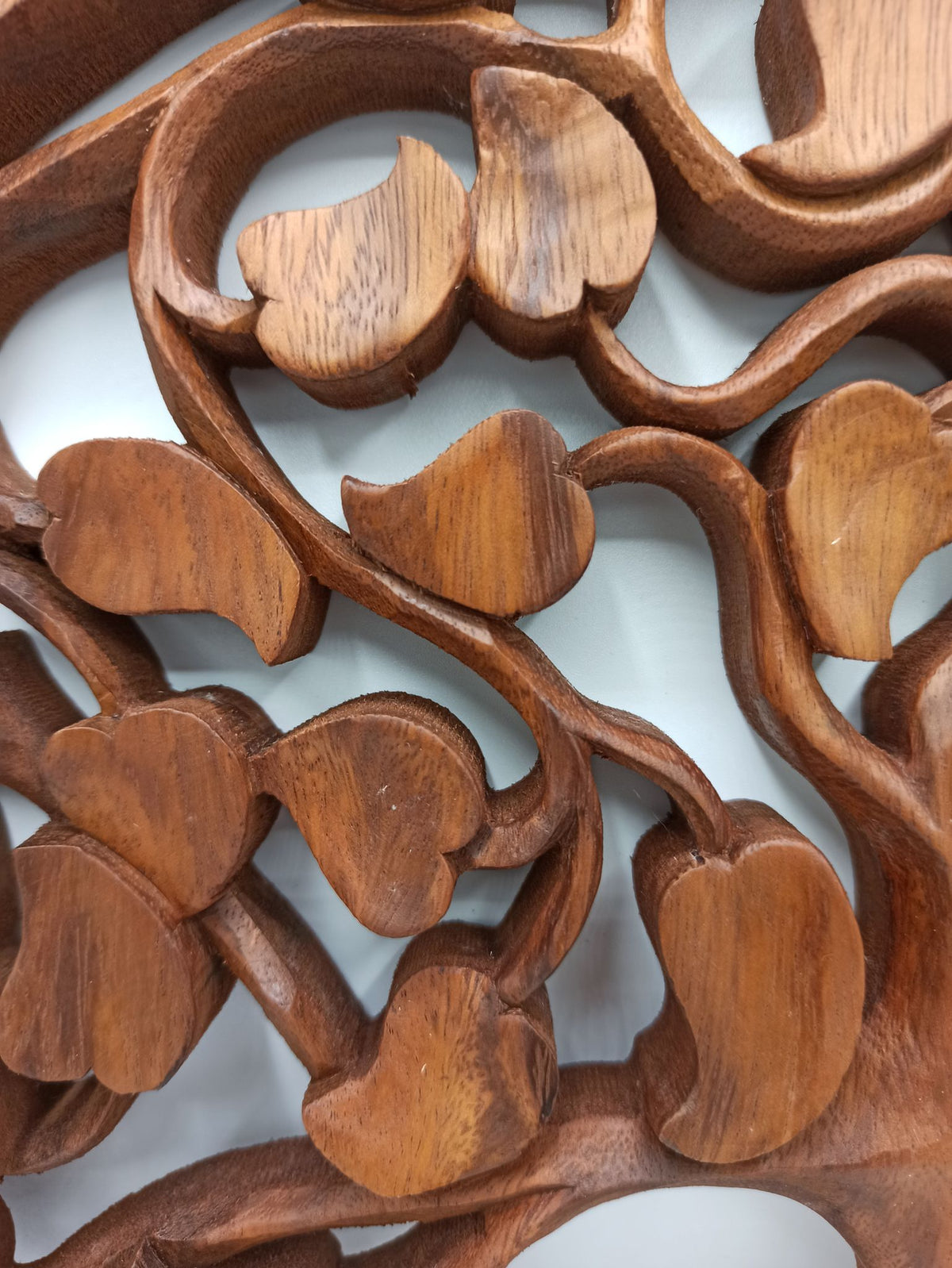 Tableau mural rond en bois de suar chantourné représentant un Arbre de Vie aux branches ornées de feuilles en forme de cœur, diamètre 40 cm. Ozora.